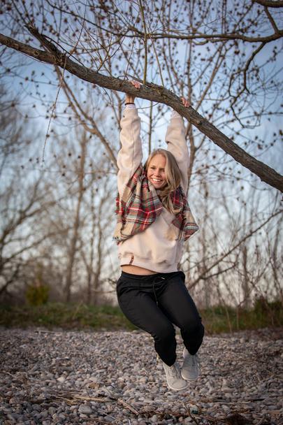 A woman swinging from a tree enjoying the ability to have fun and live without restrictions of her lungs and nervous system boundaries.