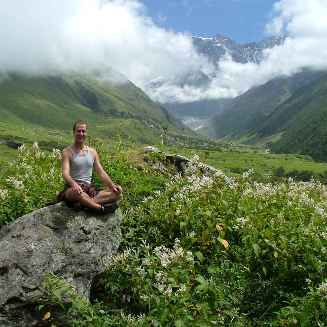 Yogi Aaron sitting on a rock in the Himalayas in India