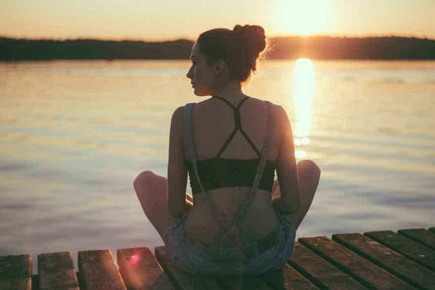 A woman enjoys some quiet time overlooking the sea.