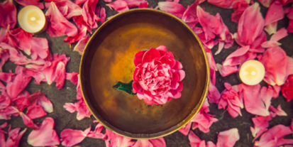 Pink flower floating on a golden bowl with water