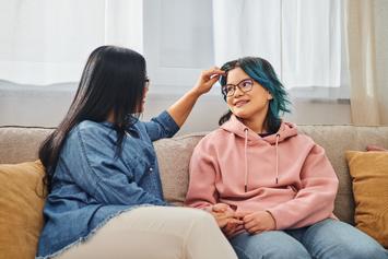 Mother and daughter talking on couch.