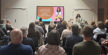 En sal fuld af tilskuere til et foredrag