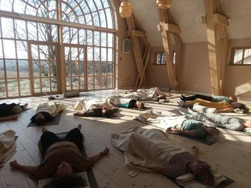 Deltagere ligger på måtter under en breathwork-workshop