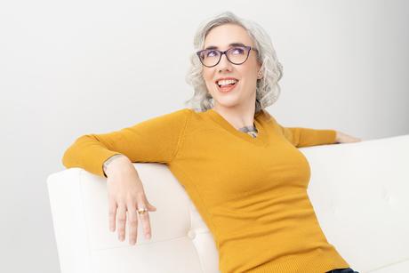 Blaze Schwaller smiling in bright light, welcoming you into a grounded, compassionate coaching journey.