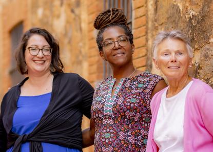 Three women stand proudly beside each other