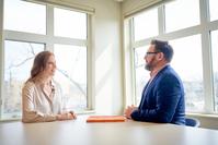 Ryan Quesnel, engaging in leadership coaching for a female executive in a middle manager role. She sits across from Ryan speaking to him about an issue she is having.