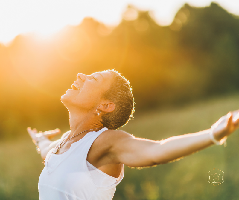 A lady with open arms in the sunlight