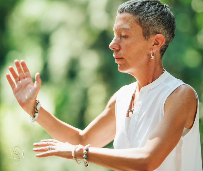 A lady performing Qigong eyes closed in nature 