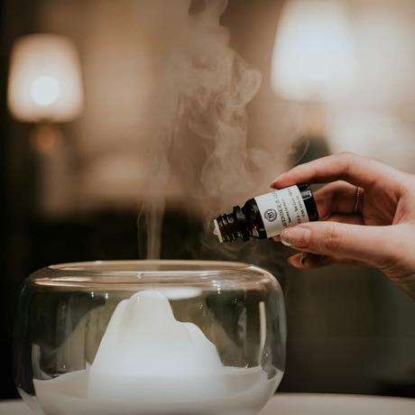 essential oil being added to diffuser during resort wellness program to create calming guest experience at eco-conscious resort