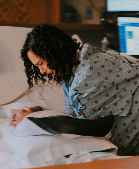pregnant woman in labor leaning over the hospital bed