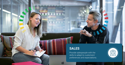 Man and woman sitting side by side looking at a laptop discussing DiSC Sales Training