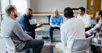 An executive team engaged in group leadership coaching session.