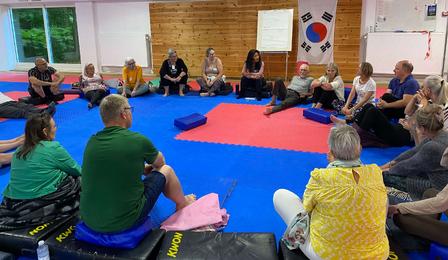 Mennesker der sidder i rundkreds til en workshop