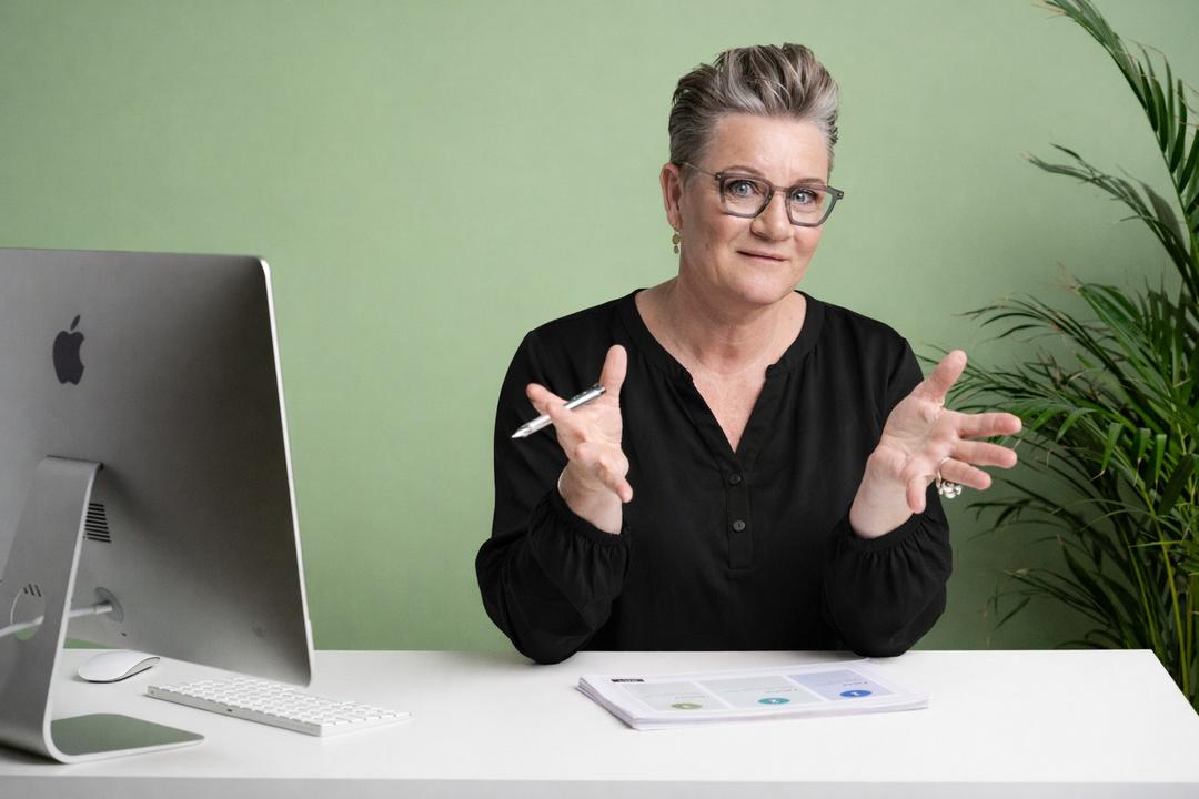 Kvinde i samtale ved skrivebord