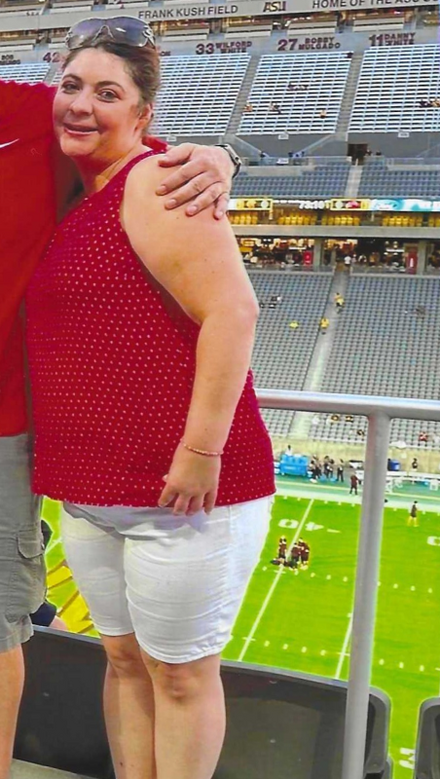 A woman standing next to a beach, doing stretches