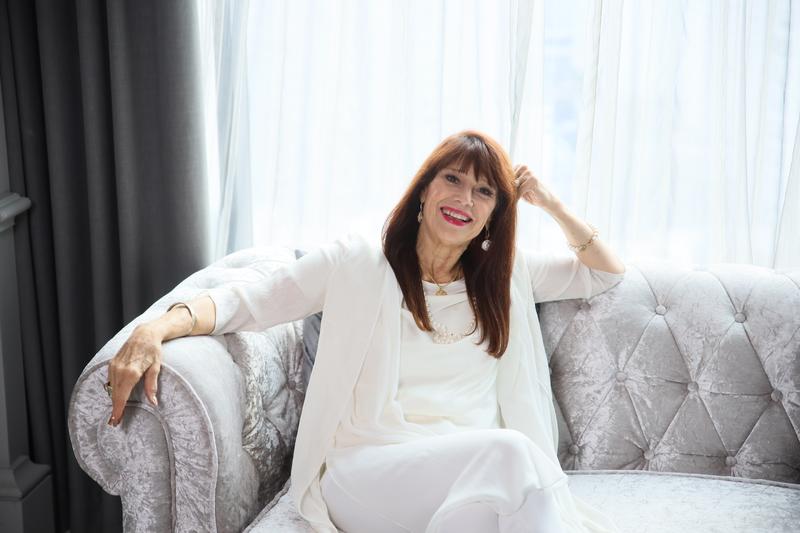 JANET IN WHITE ON COUCH Hi Res