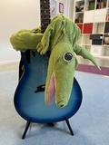 En gitarr med en krokodil hängande över sig