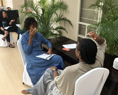 Two women sit in chairs facing each other practicing tapping using worksheets