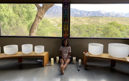 A retreat attendee meditates comfortably on the floor at the meditation retreat center, with the beautiful Arizona landscape in the background.
