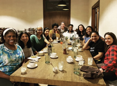 Women healthcare professionals pose for a photo together as they enjoy coffee, tea, and breakfast at the retreat center.