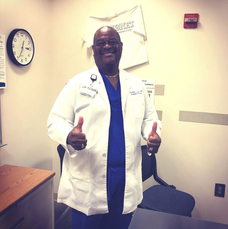 A doctor in a white coat is smiling and has his thumbs up after working with Jill