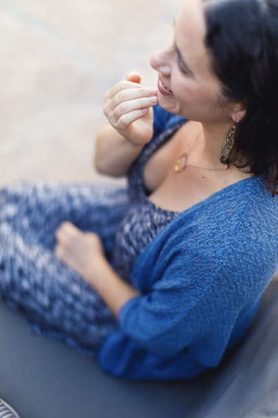 A woman in a blue sweater taps on her chin