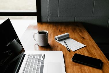 Laptop with notepad and coffee