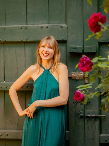 A participant on our spain retreat smiles standing next to a rose bush