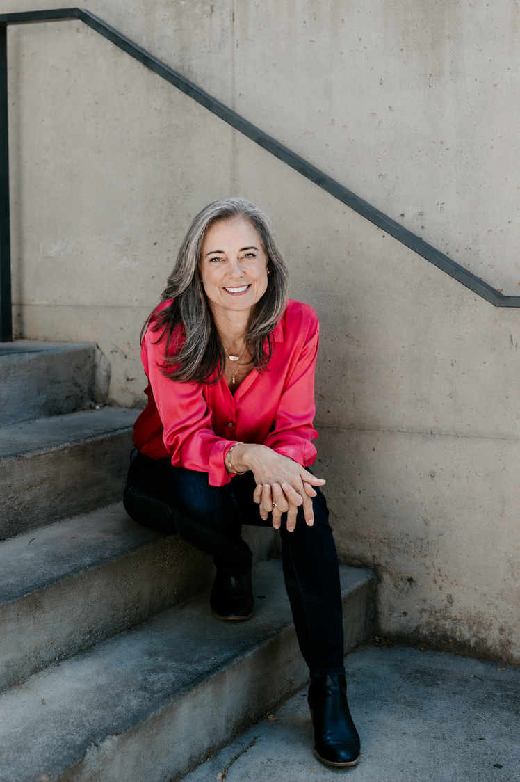 2026_susan in pink shirt sitting on concrete stairs_zoomout