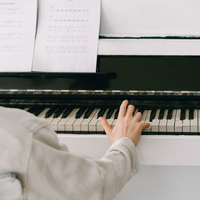A person reading sheet music at a piano