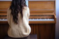 Female playing an upright piano