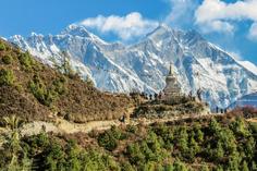 Buddhist stupa on a mountain trail below snow-capped Himalayan peaks, Nepal