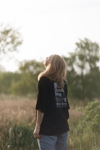 A woman looking to the sun with a field in the background bathing in the joy that being seen, and heard brings to her nervous system.