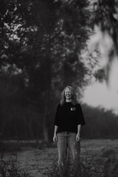 A woman looking to the sun with a field in the background bathing in the joy that being seen, and heard brings to her nervous system.