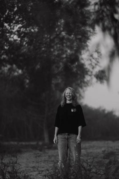 A woman looking to the sun with a field in the background bathing in the joy that being seen, and heard brings to her nervous system.