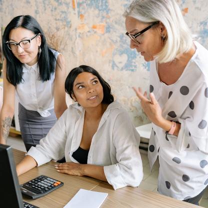 Three women looking at a computer screen in a discussion
