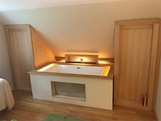 Warm lighting over the open tub, inviting the soak