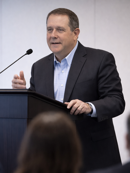 lowell speaking at a podium