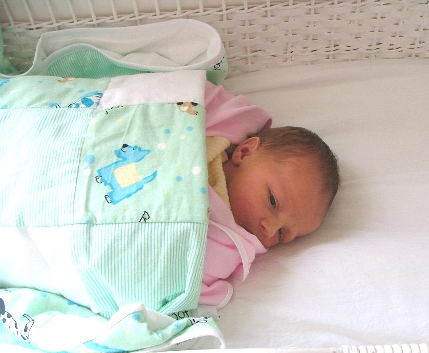 Newborn Maya sleeping in basinette
