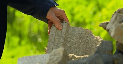hand on a pile of broken concrete