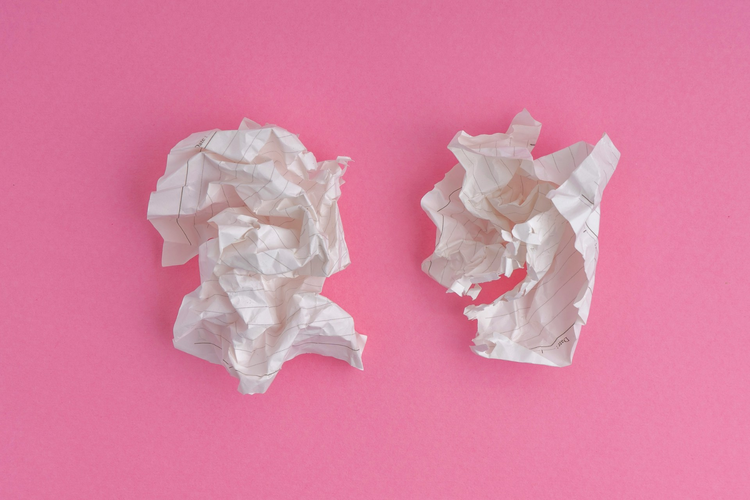 Two pieces of white paper on a pink background