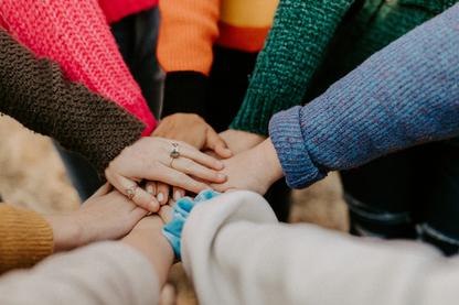 Group of hands in the middle, showcasing team work