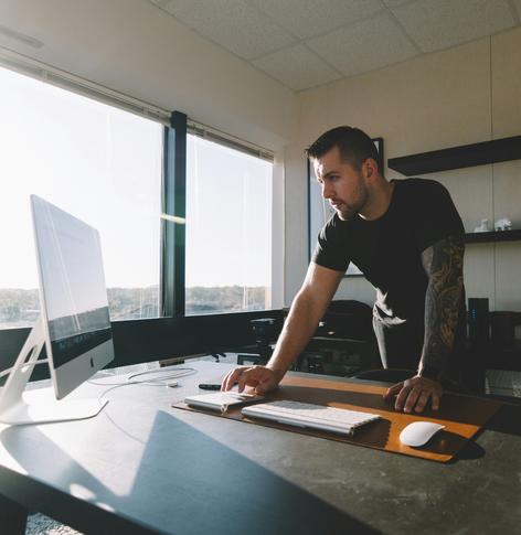 Man standing at desk using computer
