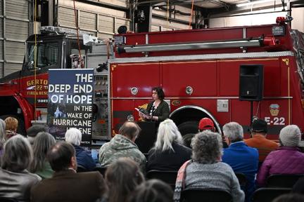 Emma at fire station with her book The Deep End of Hope