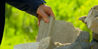 photo of a hand on broken concrete pieces