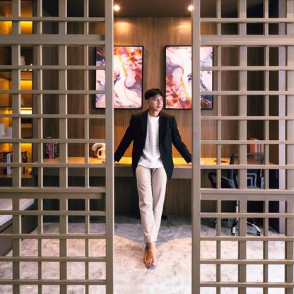 An Asian man standing in an office space