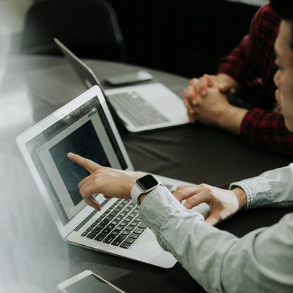 A person pointing at a laptop screen