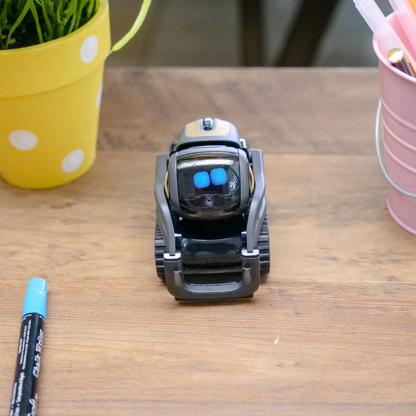 A small robot on a table with two blue light square for eyes