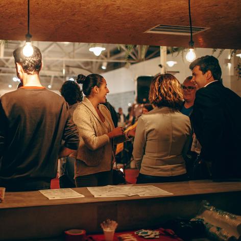 A large group of people talking near a table