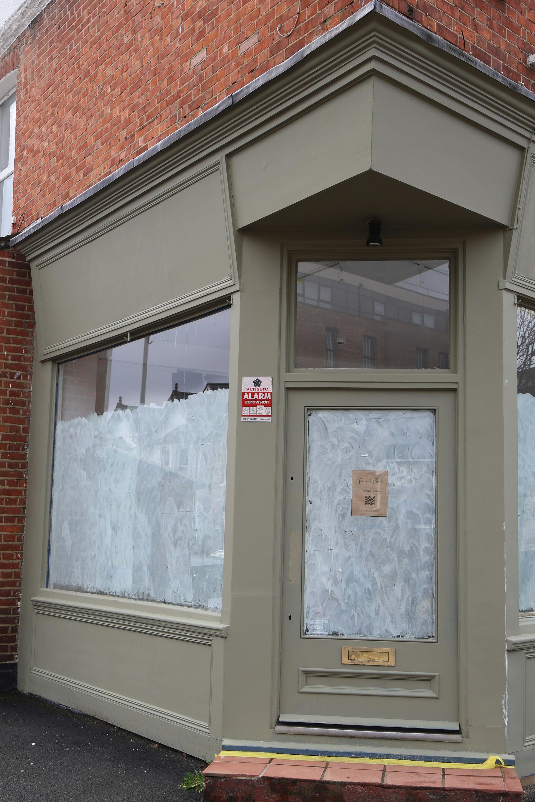 A closed storefront with boarded-up windows and a door